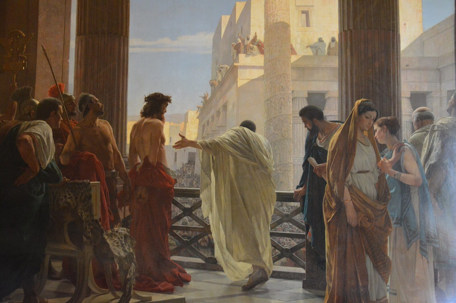 Pilate presents the bound Christ to the crowd from a palace balcony in Jerusalem.
