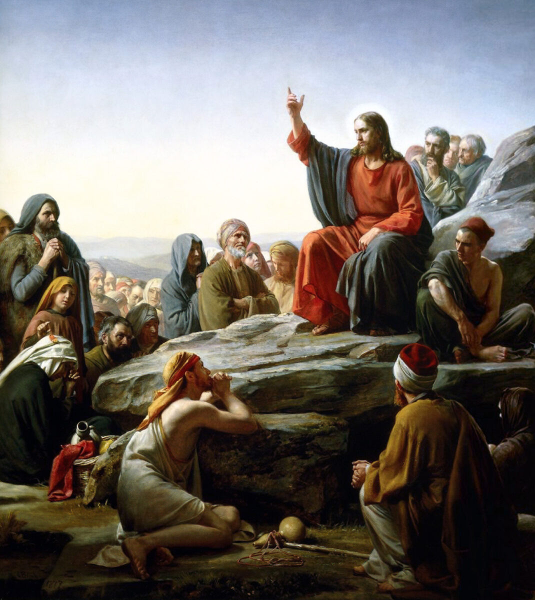 Carl Bloch’s painting of Jesus seated on a hillside teaching a crowd, with listeners gathered close around him