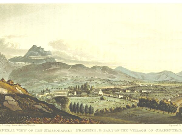 A mission church and village spread across a valley below mountains in the Cape.