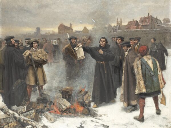 Martin Luther throws the papal bull into a bonfire before a crowd outside Wittenberg.