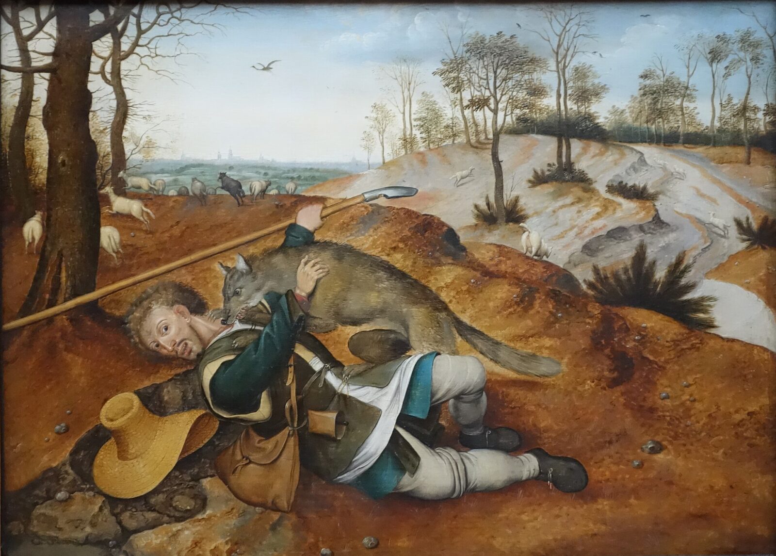 A shepherd carries a lamb on his shoulders while leading his flock through a Flemish landscape.